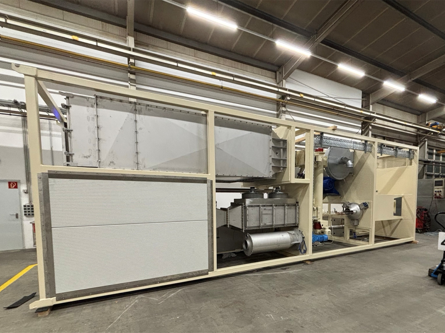 Großdimensionierte Anlagenbau‑Einheit aus Metall und Isolierelementen, montiert in einer Produktionshalle.